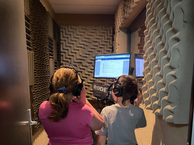 Recording the buddy radio ad, two children in a recording booth.