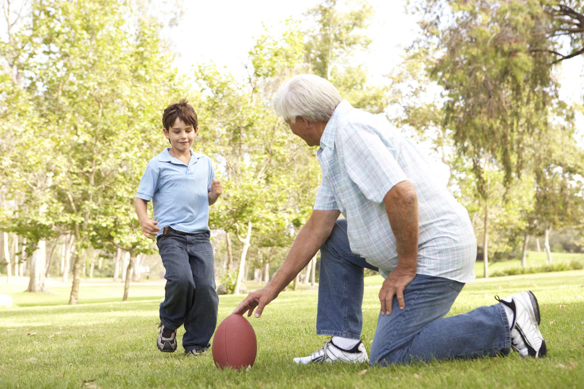 Дедушка играет в футбол. Дедушка играет в футбол с внуком. Дедушка с внуком на футбольном стадионе. Дед с мячом. Бабушка и внук занимаются спортом.